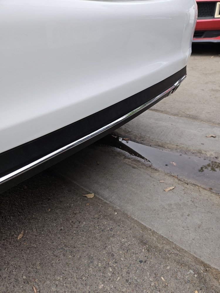White vehicle rear bumper restored to a clean finish after repair